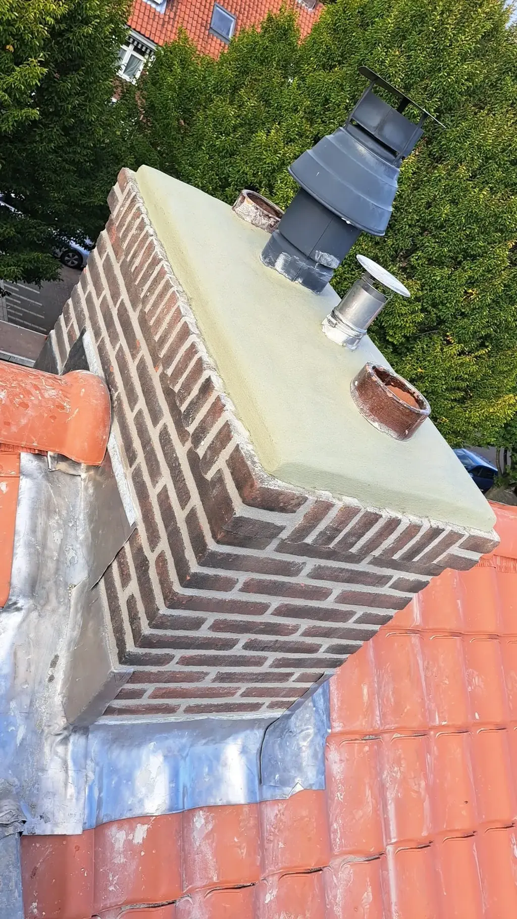 Loodaansluiting bij een schoorsteen op een pannendak, een veelvoorkomend beginpunt van lekkage