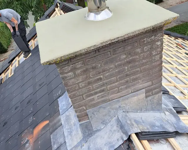 Schoorsteen op een pannendak met nieuw voegwerk en loodslabben